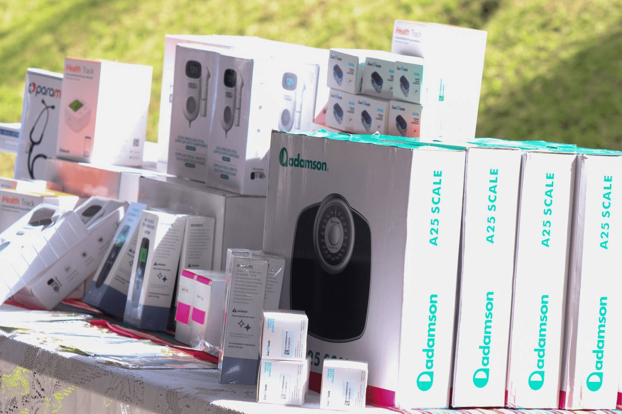 Boxes of donated health monitoring equipment and medical tools arranged on a table